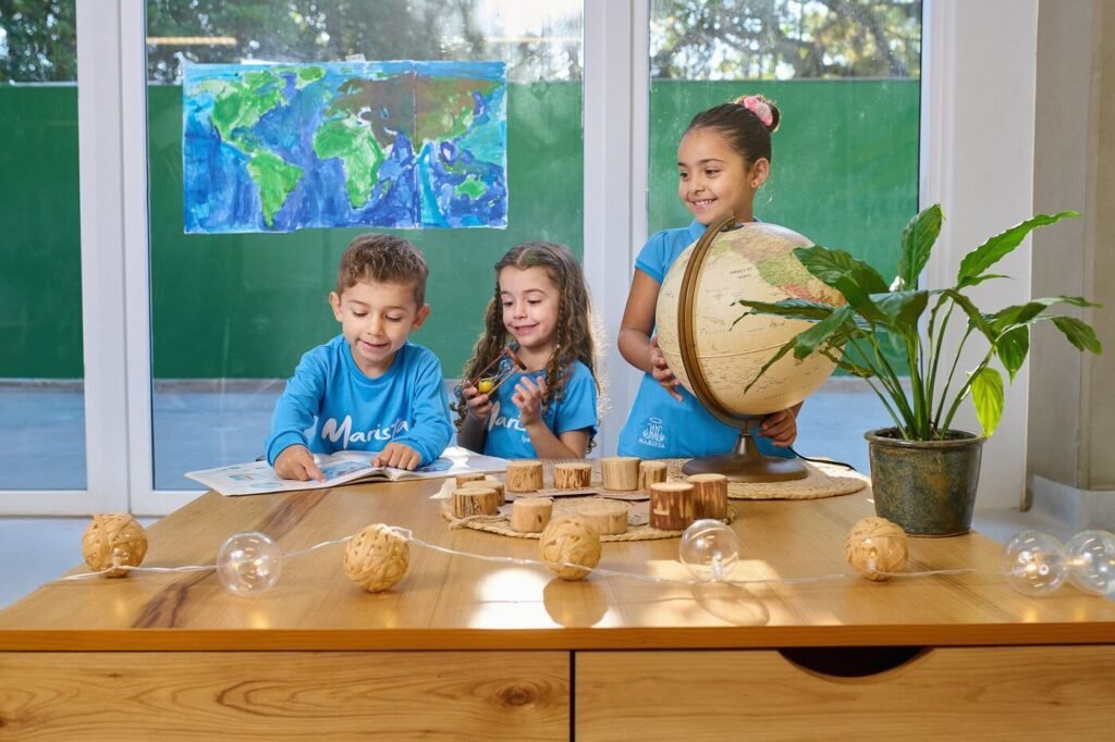 Estudantes do Colégio Marista explorando um globo terrestre em sala de aula